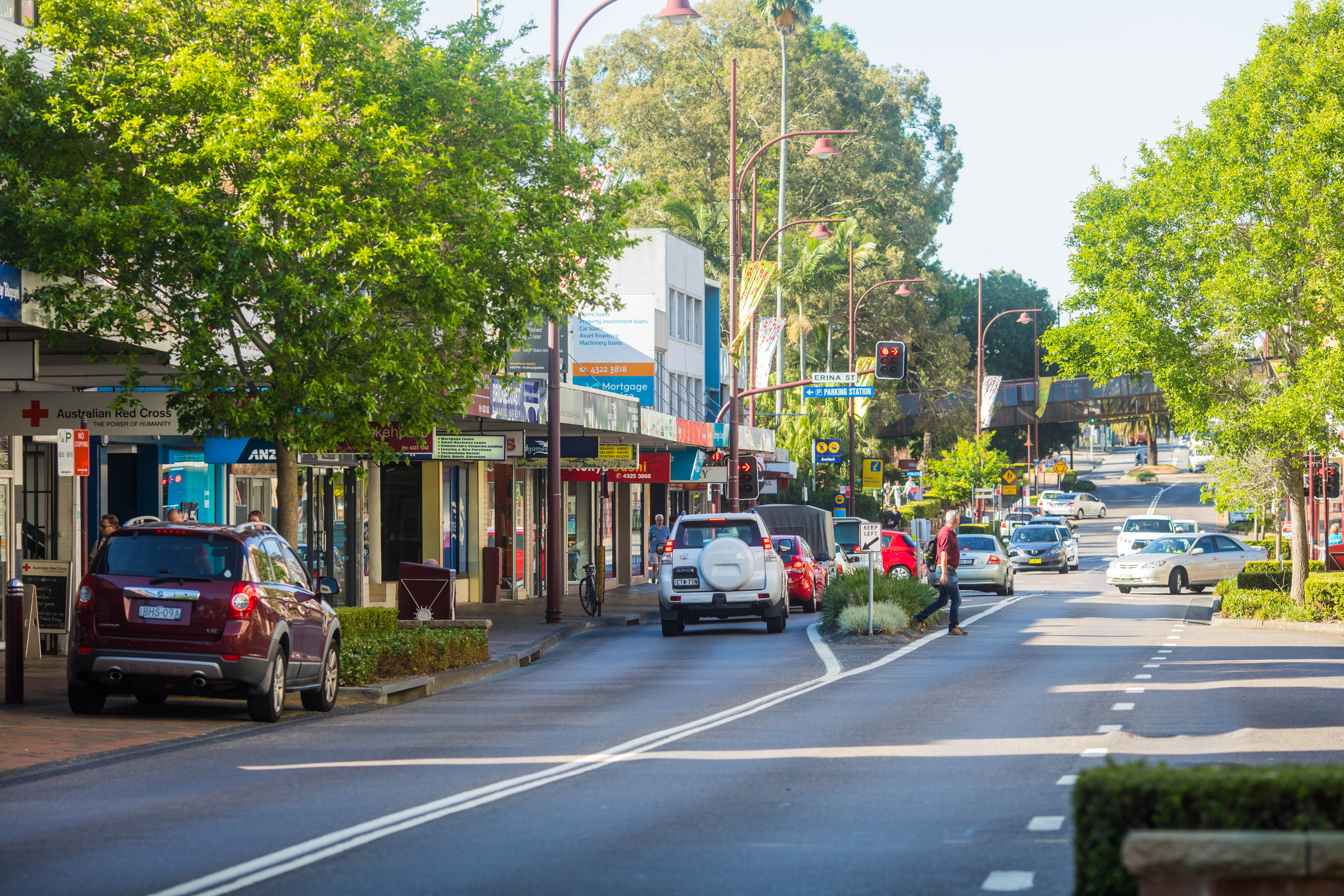 Commercial street with cars and pedestrians